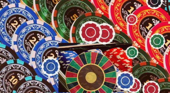 Colorful casino chips scattered over a roulette wheel, suggesting gambling and betting.
